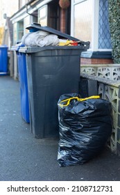 wheelie bins overflowing with rubbish waiting to be collected