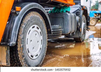 Wheels Of A Big Truck In A Mud Puddle. Close-up.