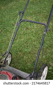 Wheels And Handle On A Push Mower In A Yard