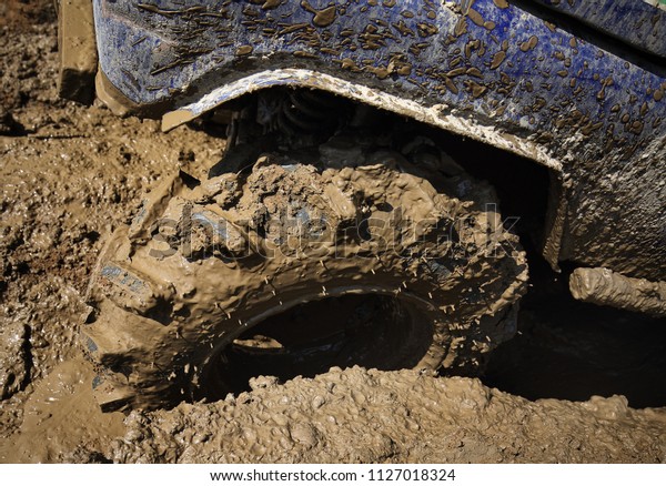 Wheels of off road car\
stuck full of mud