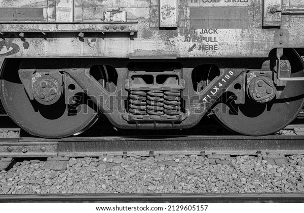 wheels of a wagon on a train rail road, zoom\
in black and white\
photography