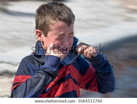 When a big wave splashed all over a 6year old boy , he started crying as he was frightened and wet.