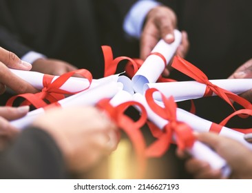 When It Comes To Education, Go All In. Shot Of A Group Of Students Holding Their Diplomas Together On Graduation Day.