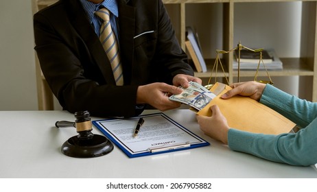 When The Court Receives Money From The Businessman In Exchange For Help The Unfair Judgment Is Corruption And Bribery, The Lawyer Holds The Pen To Sign The Contract. And Accept Bribe Offers