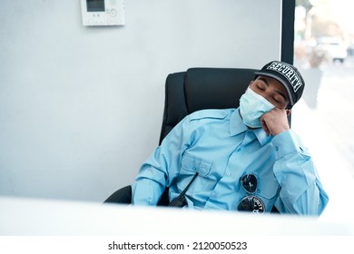 When fighting crime turns into fighting fatigue. Shot of a masked young security guard sleeping at a desk in an office.