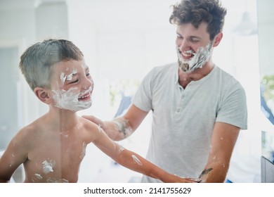 When It Gets Messy, It Gets Fun. Shot Of A Father Teaching His Little Son How To Shave In The Bathroom At Home.