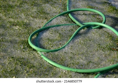 When The Hose In The Garden Freezes, The Pipe Wall Becomes Clogged And Torn. Snowy Lawn In The Garden Or Park