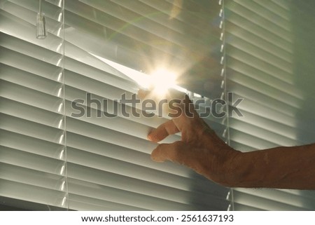 When a man's hand opens the window blinds, a bright blinding ray of sunlight streams in, filling the space with warmth and light, as if welcoming all the inhabitants of the house.
