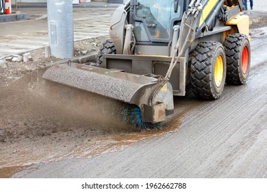 When repairing a road surface, a compact grader cleans dirt from the road to be repaired with a hydraulic nylon brush. Copy space.