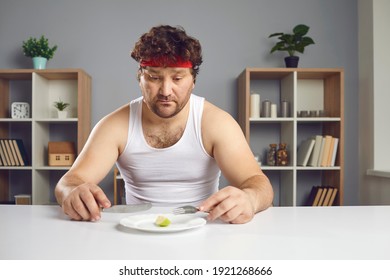 When Slimming Stops Being Healthy. Unhappy Guy Keeping Strict Diet And Eating Less Food. Sad Young Man Sitting At Table With Almost Nothing On Plate Looking At Tiny Little Portion Of Fruit For Lunch