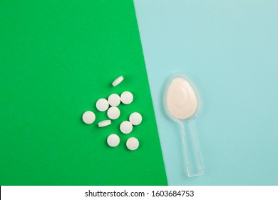 When Taking Antibiotics You Should Also Take Probiotics To Restore Good Bacteria In Gut. Balance Between Antibiotics And Probiotics Concept. Antibiotic On Spoon On Blue And Probiotic Pills On Green.