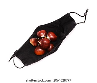 When You Go Chestnut-gathering In 2021 And Your Pockets Are Full - Black Cloth Facemask 
Full Of Sweet Chestnuts, Isolated On White Background 
