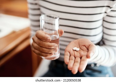 For when youre not feeling quite right. Cropped shot of a woman taking her medication at home. - Powered by Shutterstock