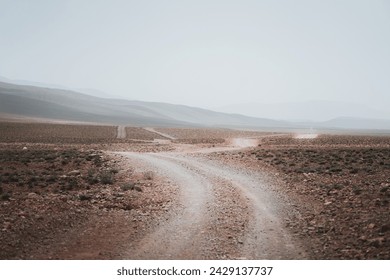 Where the earth meets the sky, the mountains of Morocco merge into a misty horizon. The winding path seems like a journey into the unknown, inviting the brave to discover its secrets. The atmosphere i - Powered by Shutterstock