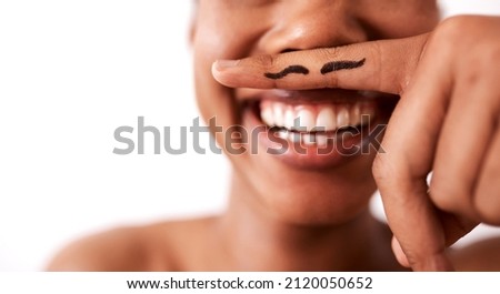 Wheres your sense of humour. Studio shot of an unrecognizable woman posing with a moustache drawn on her finger.