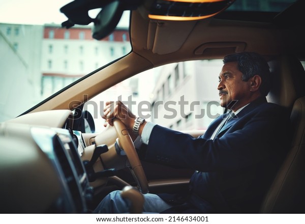 Wherever you go, arrive in style. Shot of a\
mature businessman driving a stylish\
car.