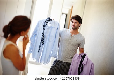 Which one do you think I should wear. Handsome man asking his wife what he should wear.