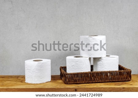 whicker basket with rolls of toilet paper on  wooden board table with copy space