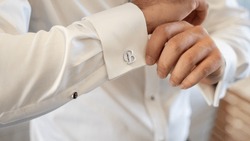"While Getting Ready Before The Wedding, The Groom Is Fastening The Cufflinks Of His Shirt.