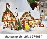 A whimsical Christmas village scene featuring Snow White and her Prince outside a festive, snow-covered cottage surrounded by woodland creatures and the Seven Dwarfs, capturing the magic of Disney