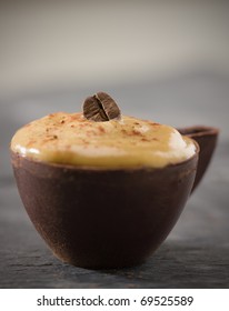 Whipped Coffee Mousse In A Dark Chocolate Cup. Very Shallow Depth Of Field.Focus On The Bean.