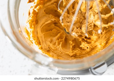Whipping ingredients in a stand electric mixer to make dulce de leche buttercream frosting.