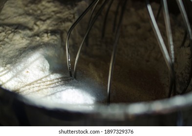 The Whisk Attachment Of A Cuisinart Stand Mixer In A Bowl Of Flour And Sugar