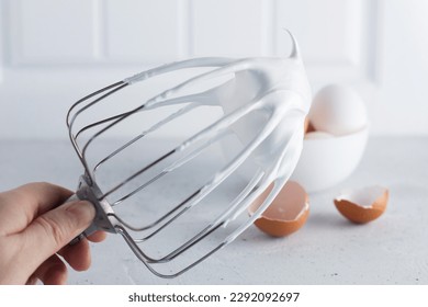 Whisked egg whites - whipped Italian meringue on a wire whisk and eggs on a gray background. copy space. - Powered by Shutterstock