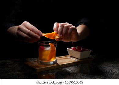 Whiskey Based Cocktail - Closeup Of Bartender Hands Preparing Old Fashioned Whiskey Cocktail On Bar Counter.