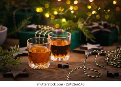 Whiskey, brandy or liquor shot and Christmas decorations on wooden background. Winter holidays concept. - Powered by Shutterstock