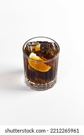 A Whiskey And Cola Cocktail Garnished With A Large Ice Cube And Lime. On A White Isolated Background.