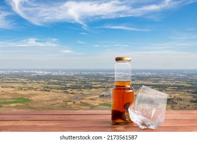 Whiskey Decanter And A Glass On Wooden Table With Blue Sky Blackground.