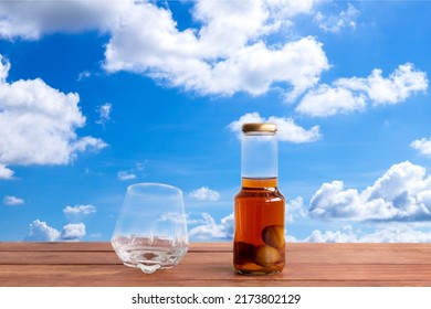 Whiskey Decanter And A Glass On Wooden Table With Blue Sky Blackground.