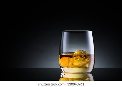 Whiskey Glass On Black Glass Surface