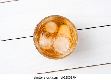 Whiskey Glass On White Wooden Table. Top View