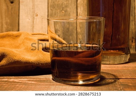 Whiskey, gloves, bottle in rustic setting