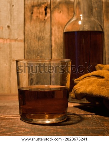 Whiskey, gloves, bottle in rustic setting