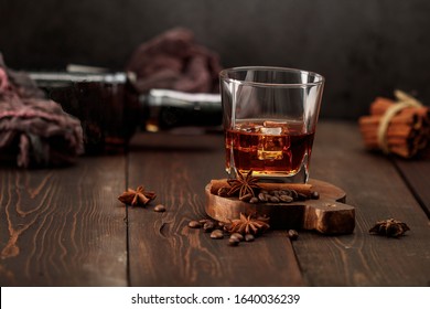 Whiskey with ice or brandy in a glass on a rustic background. Whiskey with ice in a glass. Whiskey or brandy. Selective focus.
