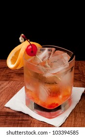 Whiskey Old Fashioned With Cherries And Orange Isolated On A Black Background