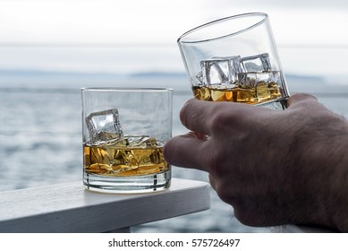 Whiskey On The Rocks, Hand Tipping Glass With Copy Space And Human Element. 