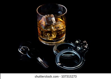 Whiskey On The Rocks With Handcuff And Car Key Against A Black Background