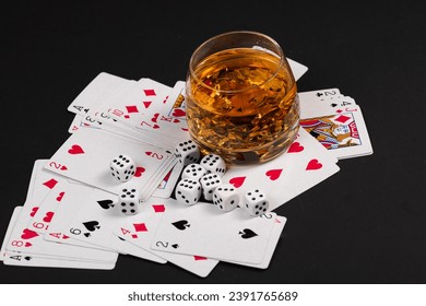 whiskey, playing cards and dice on black background, alcohol and gambling background,glass of whiskey with poker cards on the black background - Powered by Shutterstock