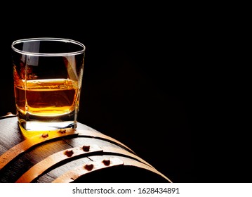 Whiskey sample, whiskey glass stands on a whiskey barrel