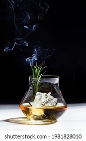 Whiskey, Scotch Or Bourbon Glass With Rosemary, Shard Ice And Smoke On Black White Background. Contemporary Still Life 