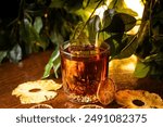 Whiskey Sour cocktail in a round glass on a table with green leaves on the background, decorated with citrus