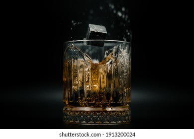 Whiskey stones splashing in the glass of whiskey