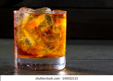 Whiskey Whisky On The Rocks On Glass Over Gray Black Background