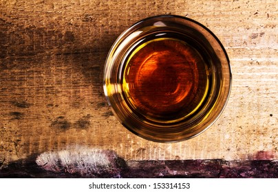 whisky Scotch  on wooden background with copyspace. An old and vintage countertop and glass of hard liquor. Top view.
