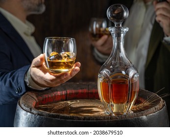 Whisky Tasting. Man Sits In Front Of A Barrel With A Decanter And A Glass Of Whiskey.