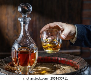 Whisky Tasting. Man Sits In Front Of A Barrel With A Decanter And A Glass Of Whiskey.